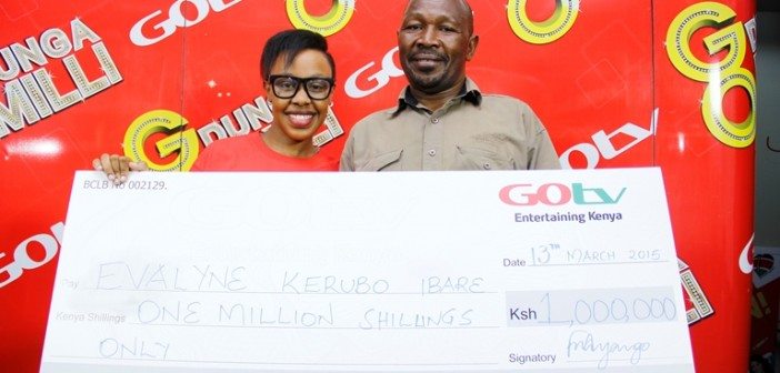 Proud dad Mr Ibare and daughter Kerubo display the dummy cheque