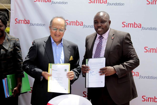 Simba Corporation CEO Mr. Adil Popat and Higher Education Loans Board CEO Mr. Charles Ringera display agreement documents after signing an agreement with Simba Foundation where students under their foundation programme will benefit from HELB loans